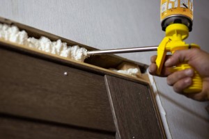 Installation of doors in the house. The master foams up the gaps between the door and the wall with polyurethane foam.